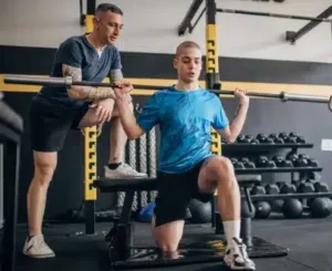 Coach sportif en salle de sport développant aussi des séances à domicile