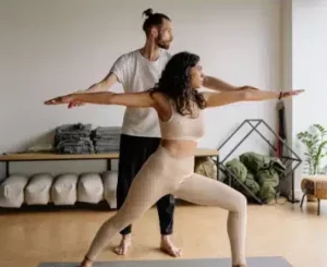 Coach donnant un cours de yoga à domicile